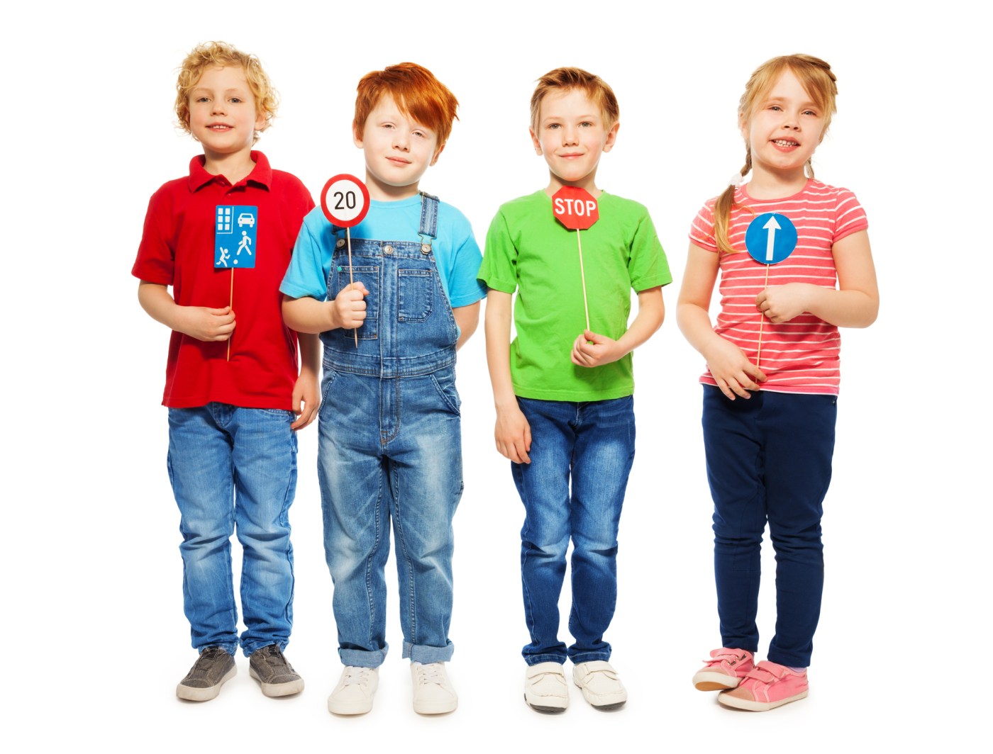 Photo showing Group of four kids, boys and girl standing in a row, holding small models of road signs