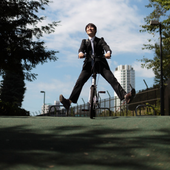 Photo of a young businessman riding a bicycle