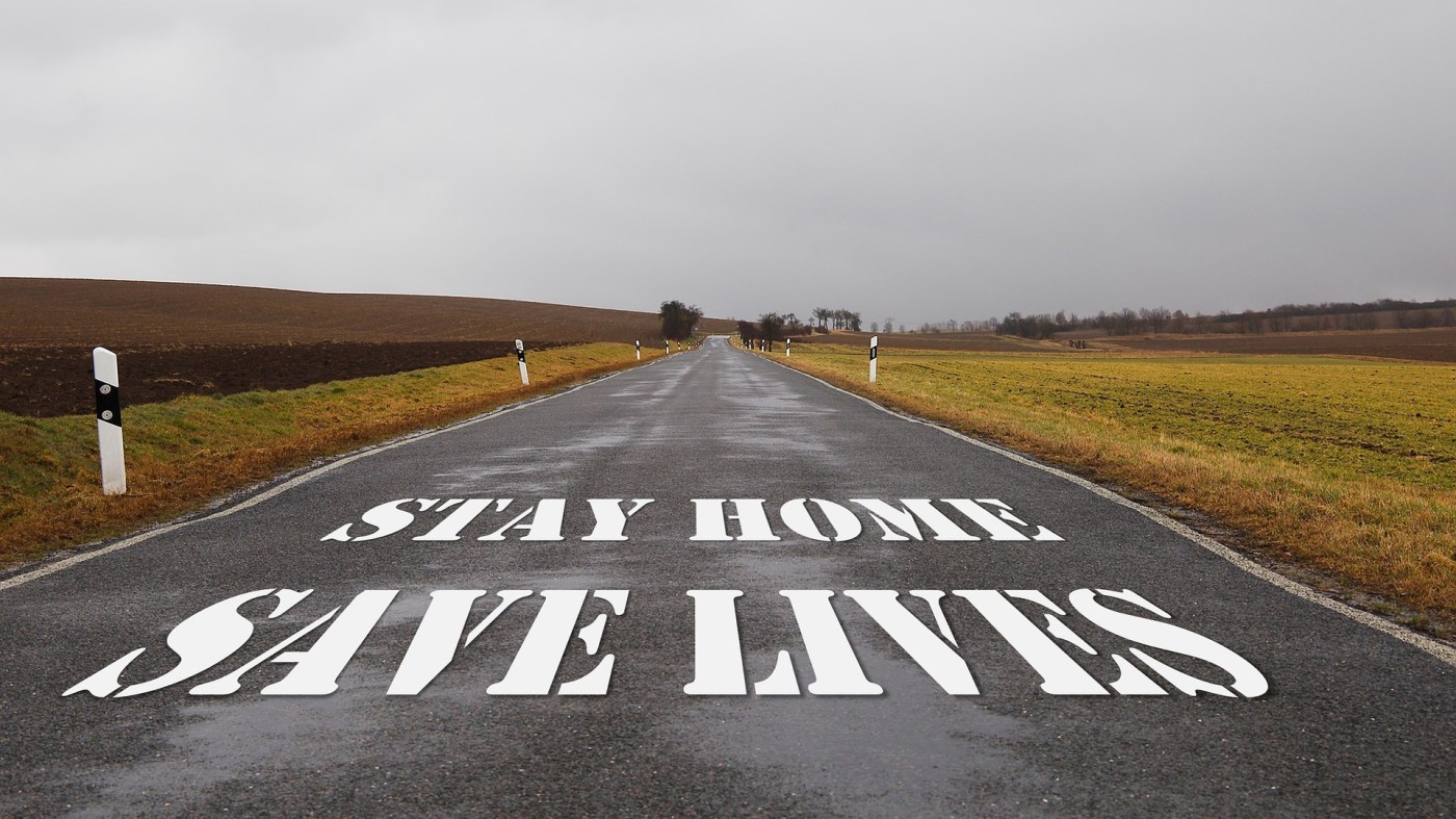 Photo of a country road, empty of traffic, with the lockdown caption "Stay Home, Save Lives" on it.