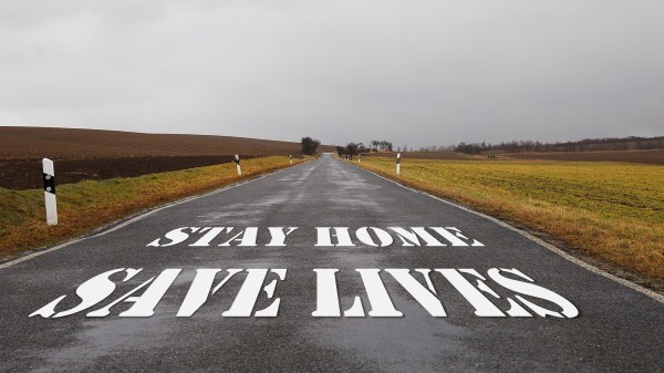Photo of a country road, empty of traffic, with the lockdown caption "Stay Home, Save Lives" on it.
