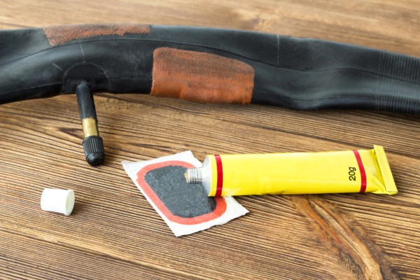 Photo of a deflated bike tyre and a puncture repair kit